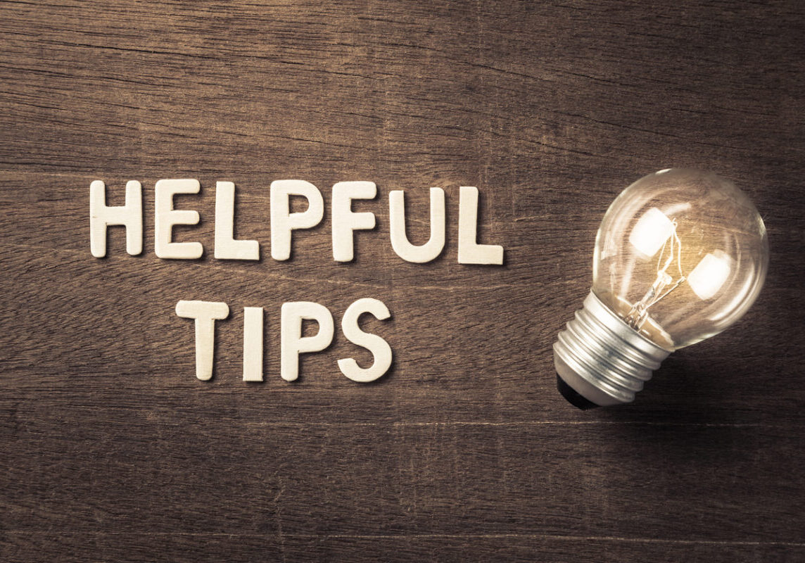 Helpful Tips text with glowing light bulb on wood texture